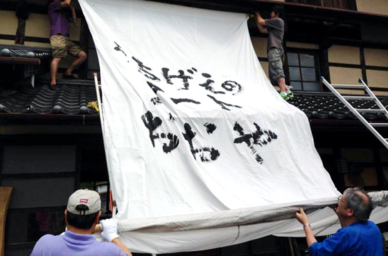 写真：大きな布かんばんをかける人たち