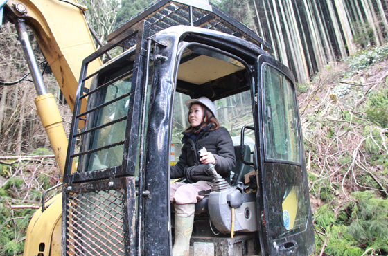 写真：林業用機械（ウインチ付きグラップル）に乗り込み操作する恵さん
