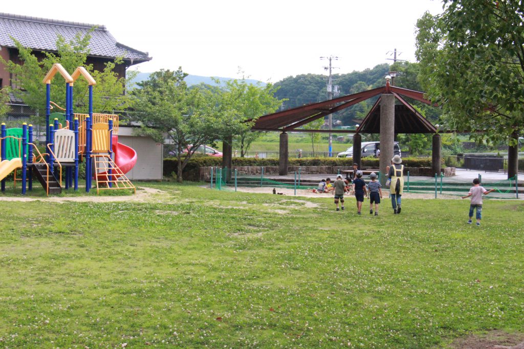 八多ふれあいセンターの外は公園があり、職員の方と外遊びをする子どもたち。